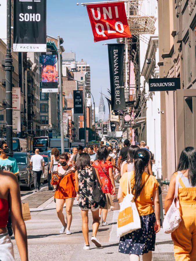 A busy shopping street lined with store banners
